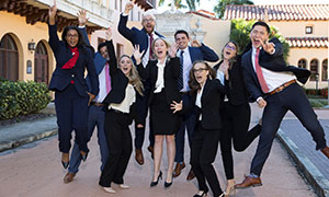 law students playfully jumping together on campus