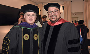 a faculty member posing at commencement