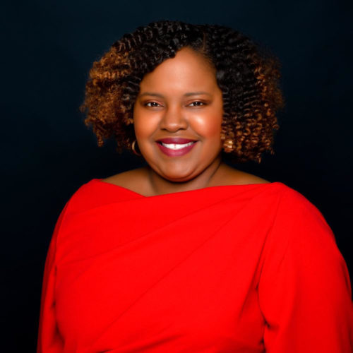 A headshot of Stetson Law alumna Theresa Jean-Pierre Coy, who is pictured smiling and wearing red.