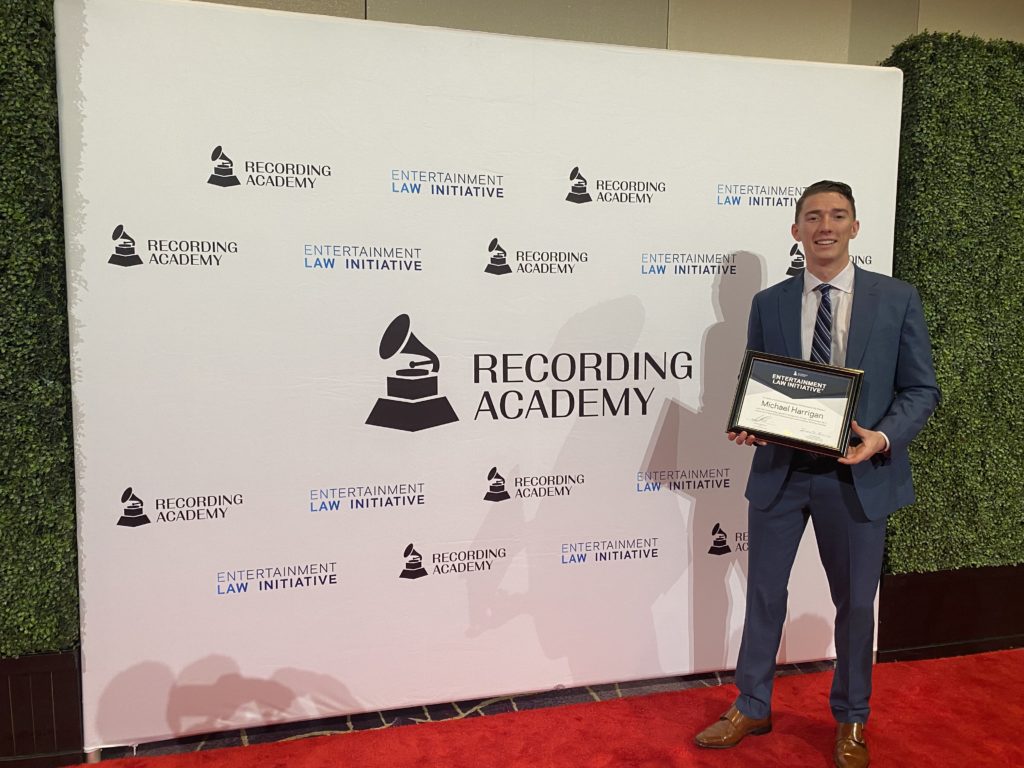 Stetson Law Student Michael Harrington holds a plaque recognizing his winning essay at a GRAMMY week event.