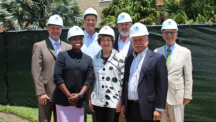 Stetson officials wear hard hats in front of the construction site of the new Advocacy Institute