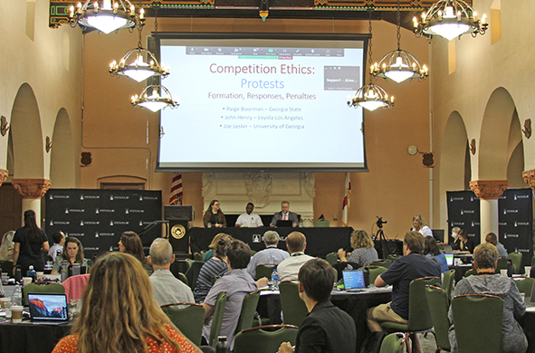 A room full of conference attendees watches a presentation on competition ethics in Stetson Law's Great Hall