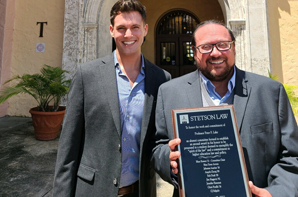 A Stetson Law alumnus stands next to a Stetson Law Professor in front of an entrance to the College of Law.