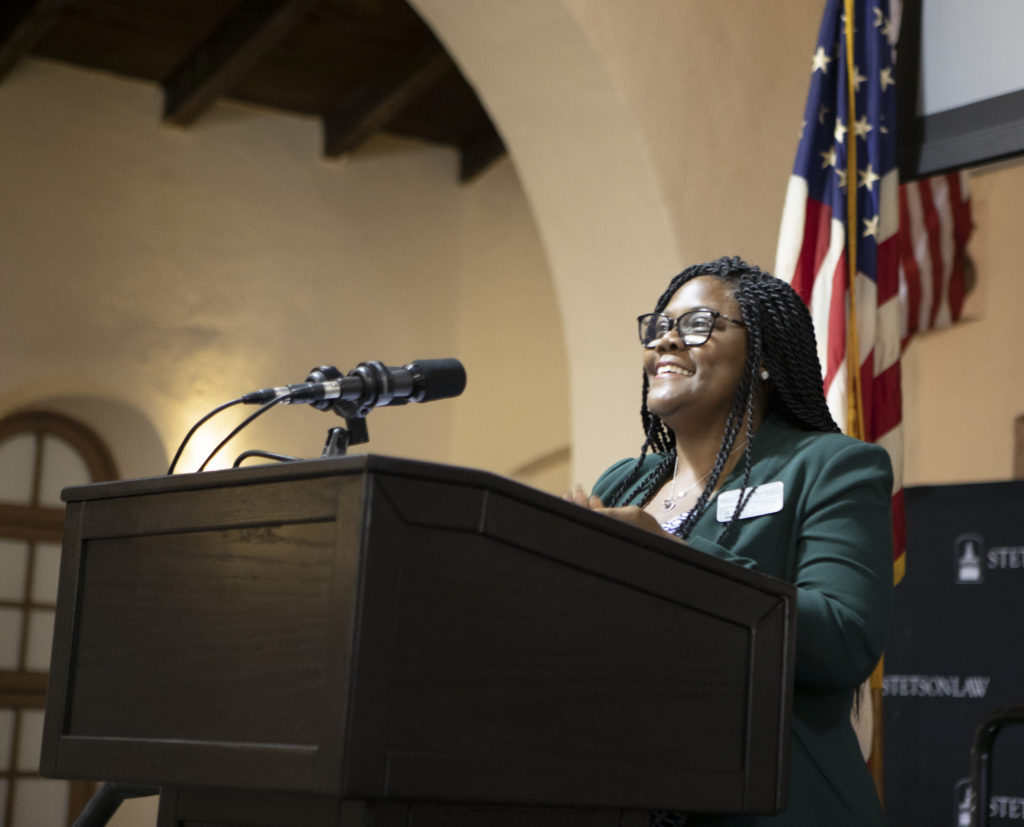 A woman speaks at a podium in the Great Hall.