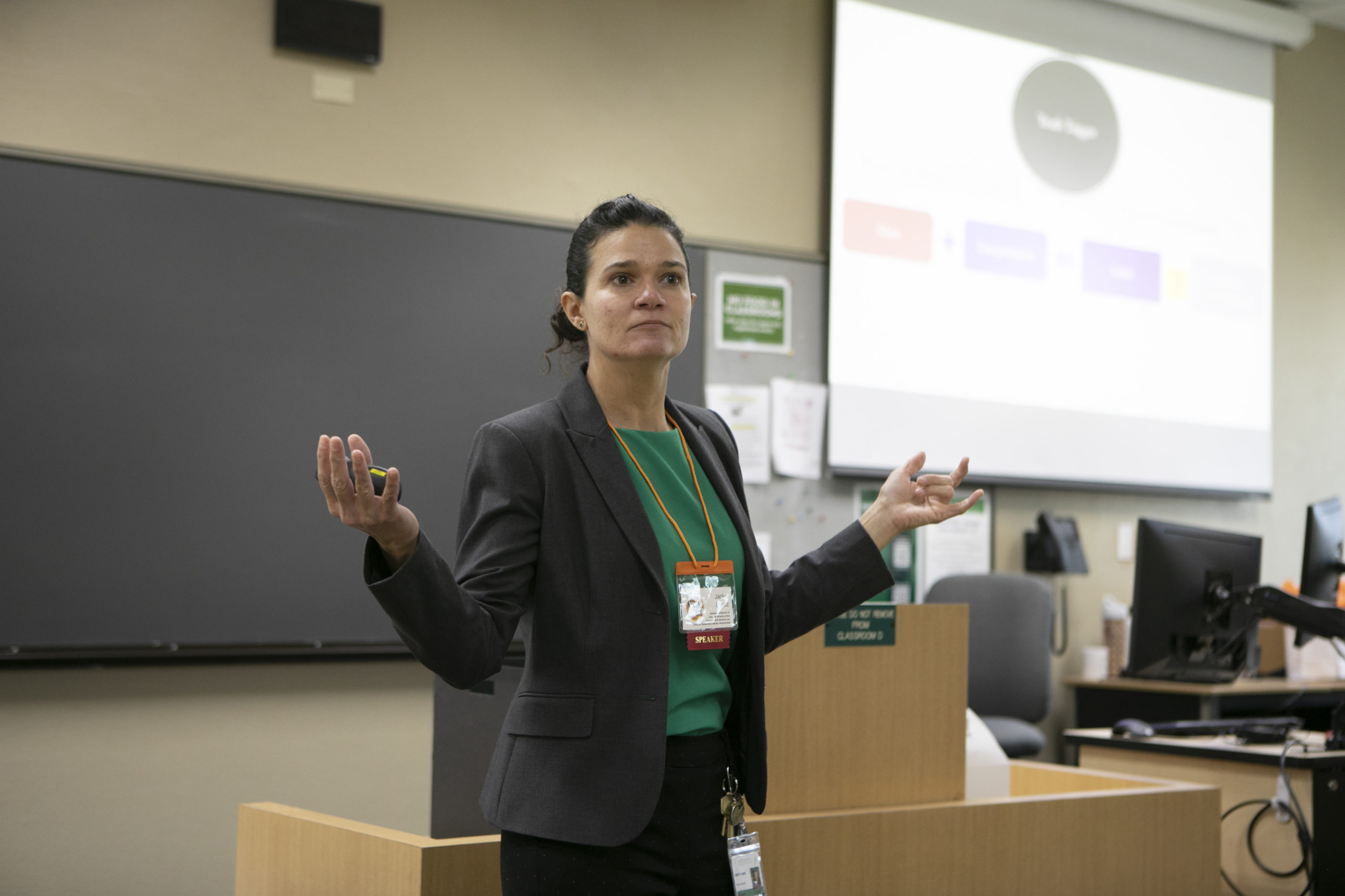 A female law professor in a green shirt addresses a classroom.
