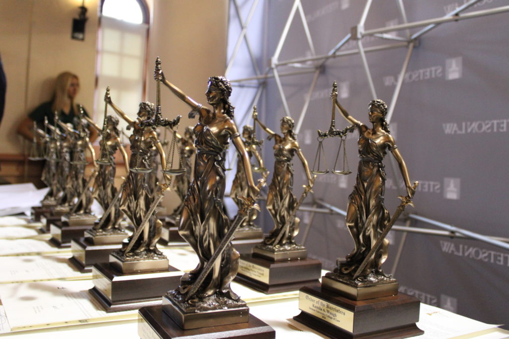 A group of small bronze statues depicting Lady Justice