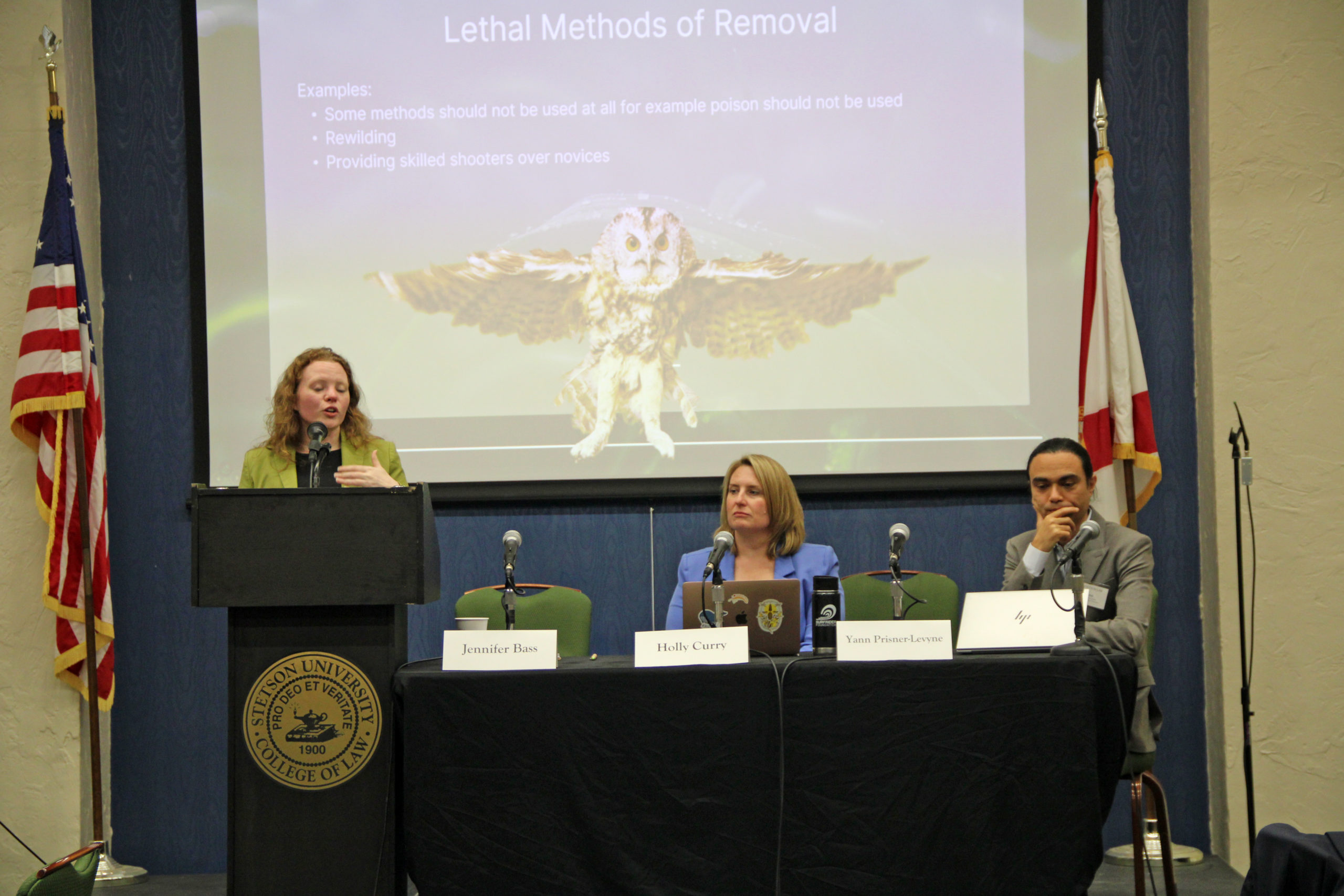 A woman leads a panel discussion about humane wildlife management methods.