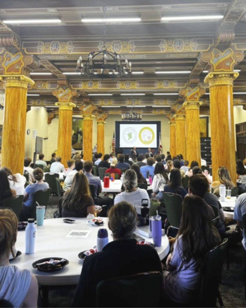 A photo of a room full of people from the back of the Mann Lounge
