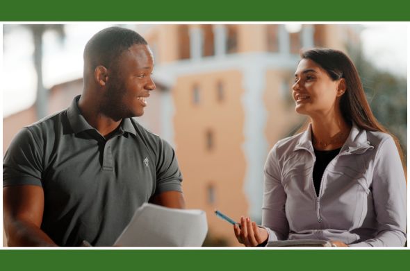 A male and a female student smile as they converse in front of the Stetson Law tower building.