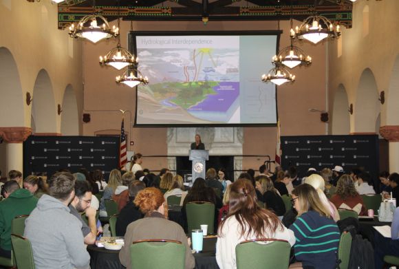 A woman at a podium speaks to a large audience in Stetson Law's Great Hall.