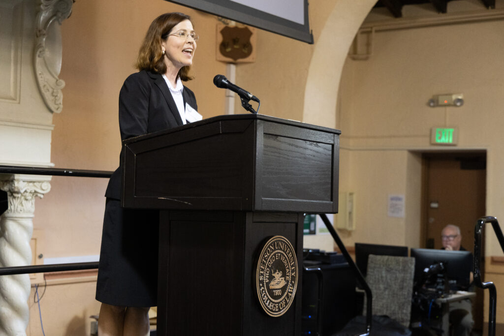 A woman wearing a dark suit stands at a Stetson Law podium.