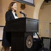 A woman wearing a dark suit stands at a Stetson Law podium.