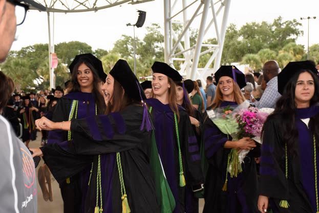 A group of graduates socializes after a graduation ceremony.