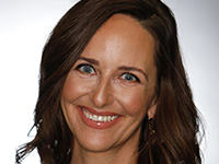 A headshot of a smiling woman with dark hair and light eyes.