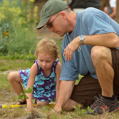 Visiting Research Professor John Jett and his daughter Maya plant a tree on campus. Photo by Dr. Peter May.      