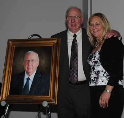 Bobby Adams and wife, Ann, pose with the oil portrait unveiled at the Hall of Fame ceremony Feb. 2.