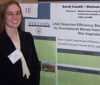 Sarah Caudll, in college, stands in front of her senior research display