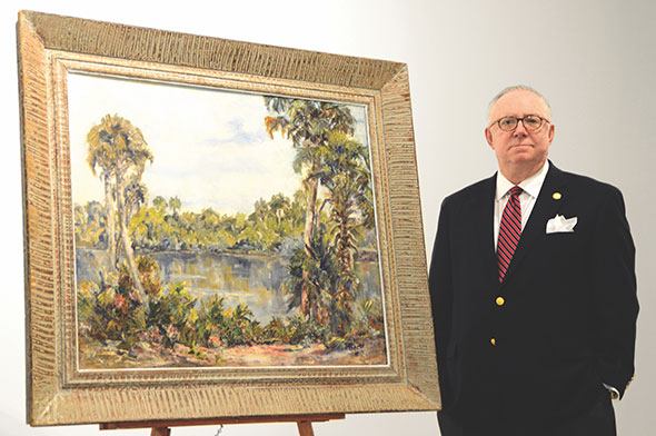 Exhibition guest curator Gary Libby stands next to "Landscape South of Englewood, Florida," a painting by Lois Bartlett Tracy (1901-2008). 