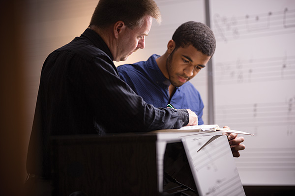  Noel Painter, Ph.D., interim executive vice president and provost and an associate professor of music, assists student Marcus Jones.