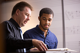 Professor Noel Painter, Ph.D., works with a student in a music class.