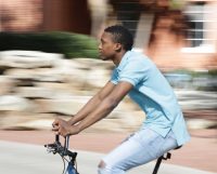 Alex Greene rides his bike across campus