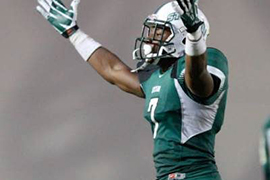 Donald Payne on the football field, raises his hands to rev up the crowd.