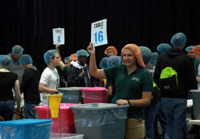 Big room full of volunteers with food supplies