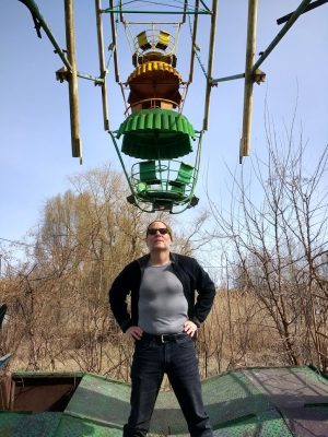 Michael Denner stands under old amusement ride