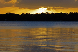 The sun sets over Lake Beresford, casting a pretty orange sky