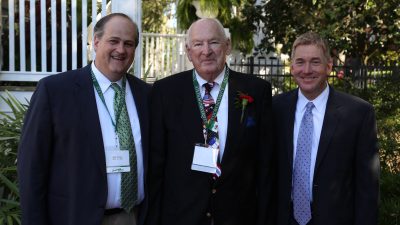 the three stand side by side in suits and ties.