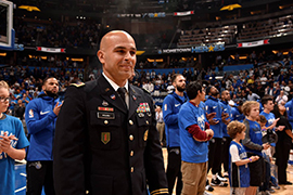 Stetson student in military uniform being honored on the court at a Magic basketball game