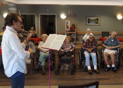 Zach Foss plays the violin as residents of the Lutheran nursing home listen.