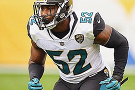 Donald Payne, wearing his Jacksonville Jaguars uniform, readies for a play on the football field.