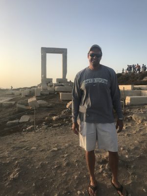 Jason Maddox stands amid ancient ruins in Greece.