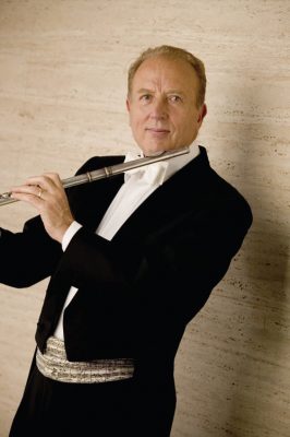William Bennett stands in black tux holding a flute