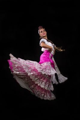 Janereth Vargas Cervera performs a folkloric dance in a colorful ornate costume.