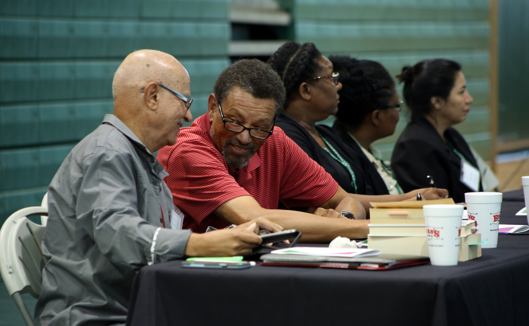 Maurice Woodard leans over to speak to Franklin Biggins on the panel at the luncheon.