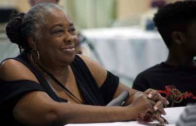 Dottie Johnson sits listening at a banquet table in the Rinker Field House