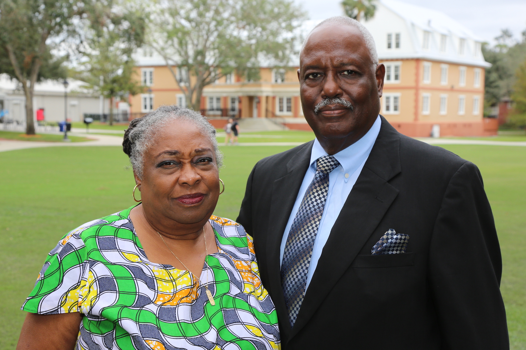 The two stand on the Stetson Green with Conrad Hall in the background.