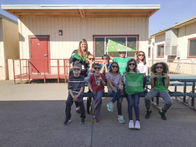 Sarah Stetson and her fourth grade class wave pennants and other Stetson memorabilia outside their portable classroom in California