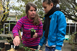 Sarah Cramer talks to a student next to the school garden