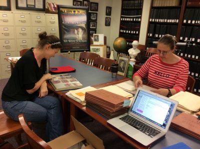 The two professors read through documents and other items in the Stetson archives