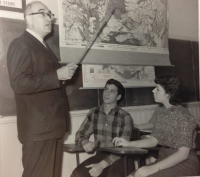 Professor Serge Zenkovsky stands at a map of Russia with a pointer as two Stetson students look on in this historical black and white photo from Stetson
