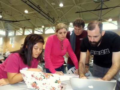 The four of them are hunched over two laptops at last April's hackathon.