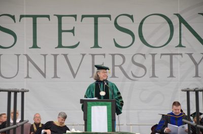 Wendy Libby at the podium on stage with Stetson banner behind her.
