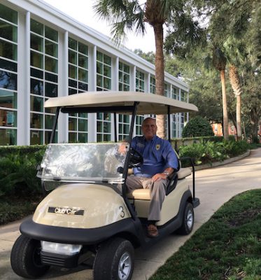Chief Matusick takes a break in a Stetson golf cart outside the library on campus.