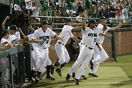 Team jumps and cheers, pouring out of the dugout, after win on Sunday night.