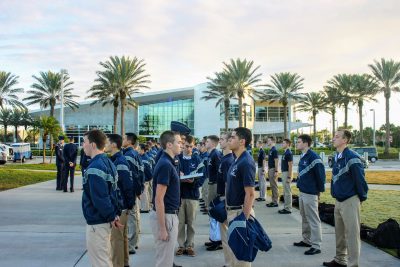 A group of cadets stand at attention outside an academic building at ERAU.