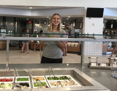 The Stetson student stands smiling at the salad bar.