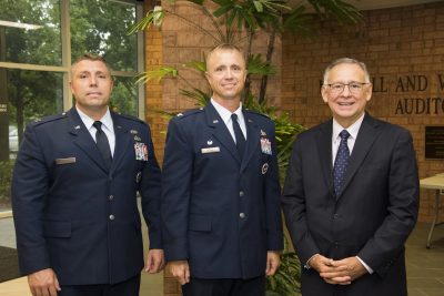 Two Air Force officers in uniform stand beside Neal Mero, dean of the business school.